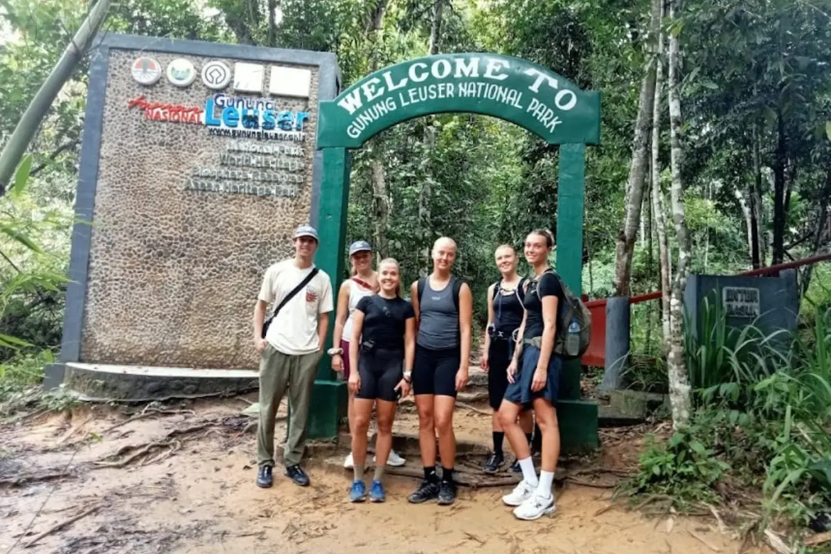 Tourists posing at the entrance gate of Gunung Leuser National Park Sumatra